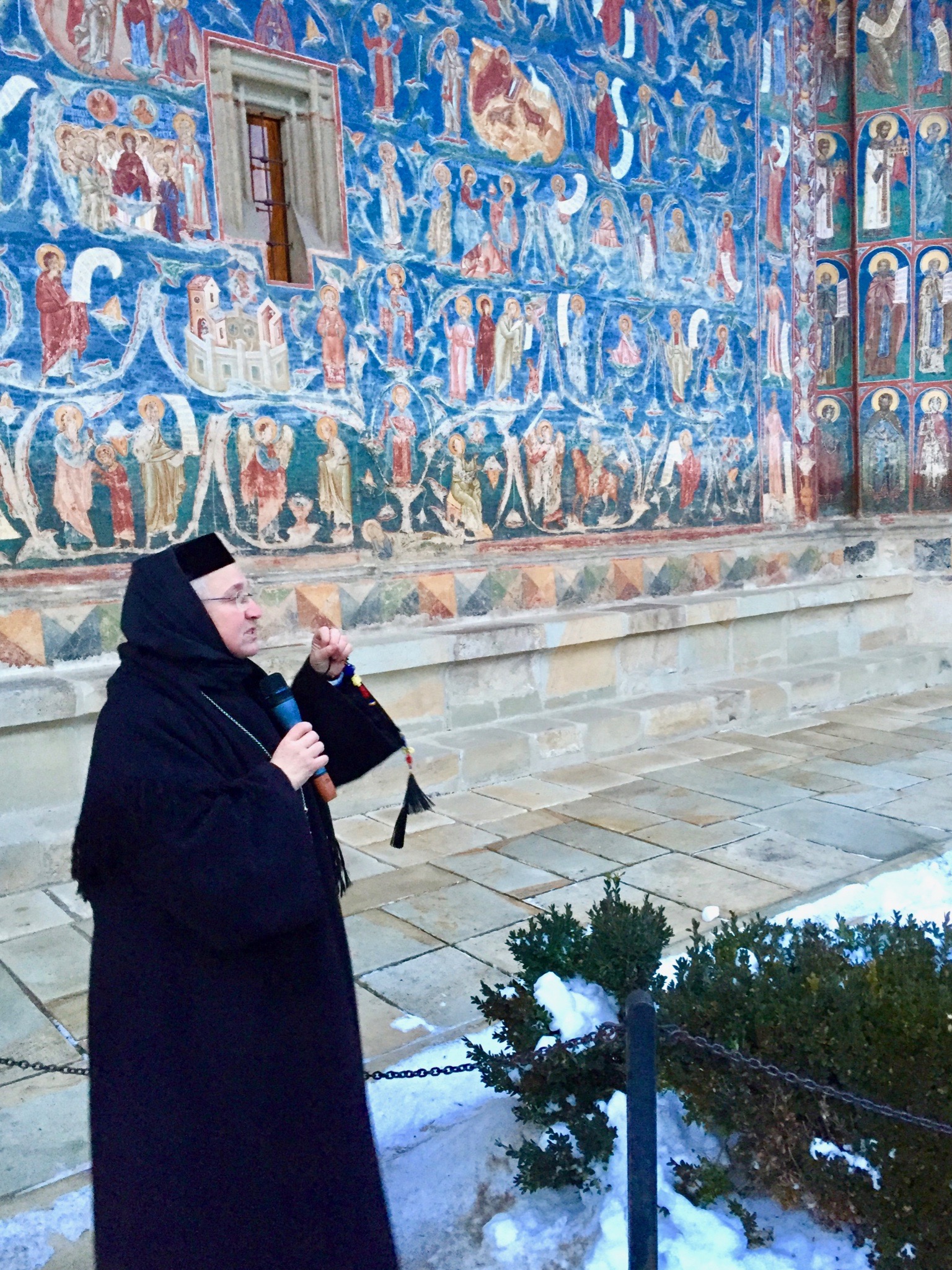 Nun in front of blue wall in Iasi, Romania